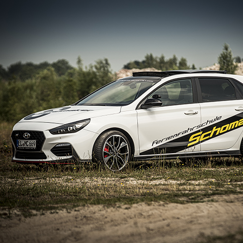 Weißer Hyundai i30 N der Fahrschule Schomaker-Behrens mit gelb-schwarzer Beklebung
