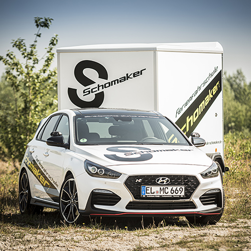 Hyundai i30 N der Fahrschule Schomaker-Behrens mit dem eigenen Anhänger, auf dem das S-Signet steht
